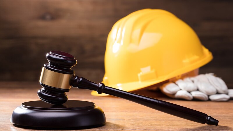 Richterhammer und gelber Bauhelm auf einem Holztisch (© iStock AndreyPopov)