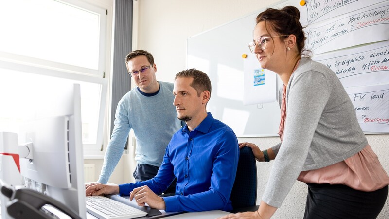 Drei Personen arbeiten gemeinsam an einem Computer in einem Büro. (© Julia Otto / LBV)