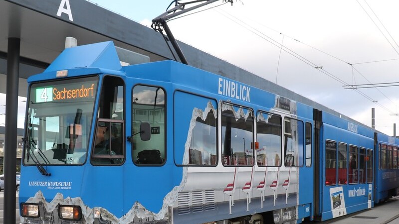 blaue Straßenbahn an Haltestelle