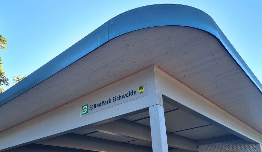 gebogene Dachkonstruktion mit Schild des Radparks Eichwalde