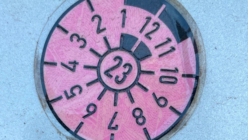 Plakette am Auto, die den Zeitraum der technische Überwachung ausweist