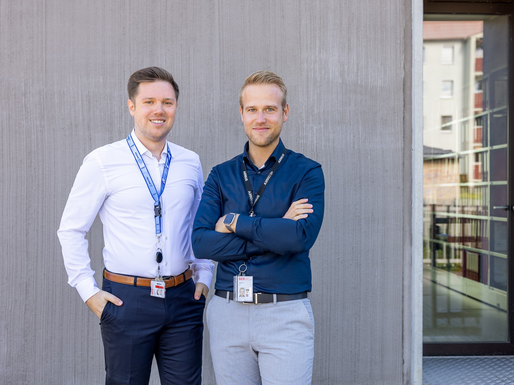 zwei junge Männer stehen vor einem Haus