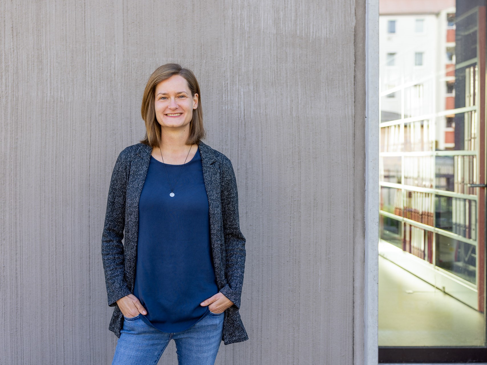 junge Frau steht vor einem Haus