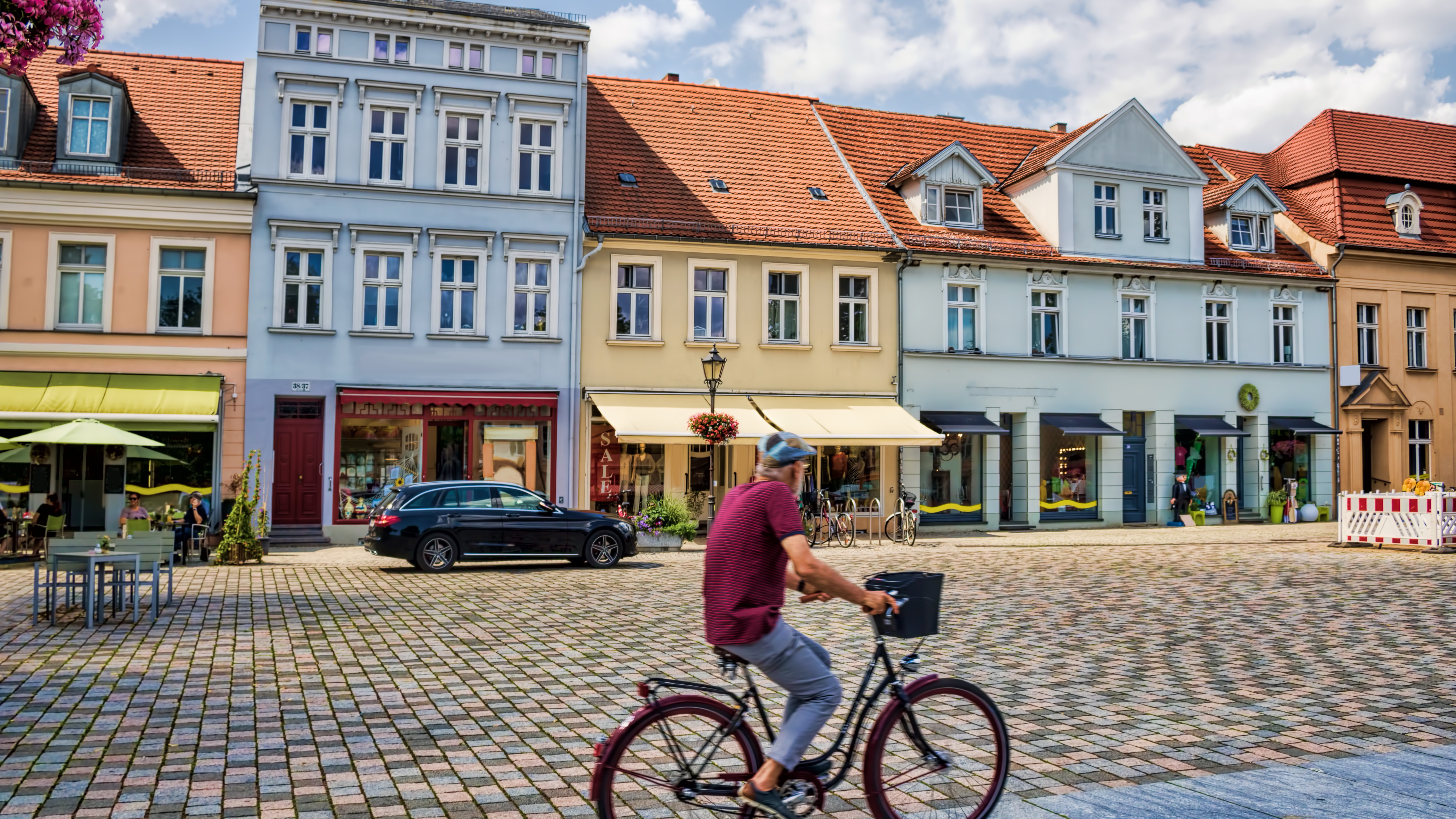 Bild: Sanierte Häuser im Stadtzentrum, im Vorgerund ein Radfahrer